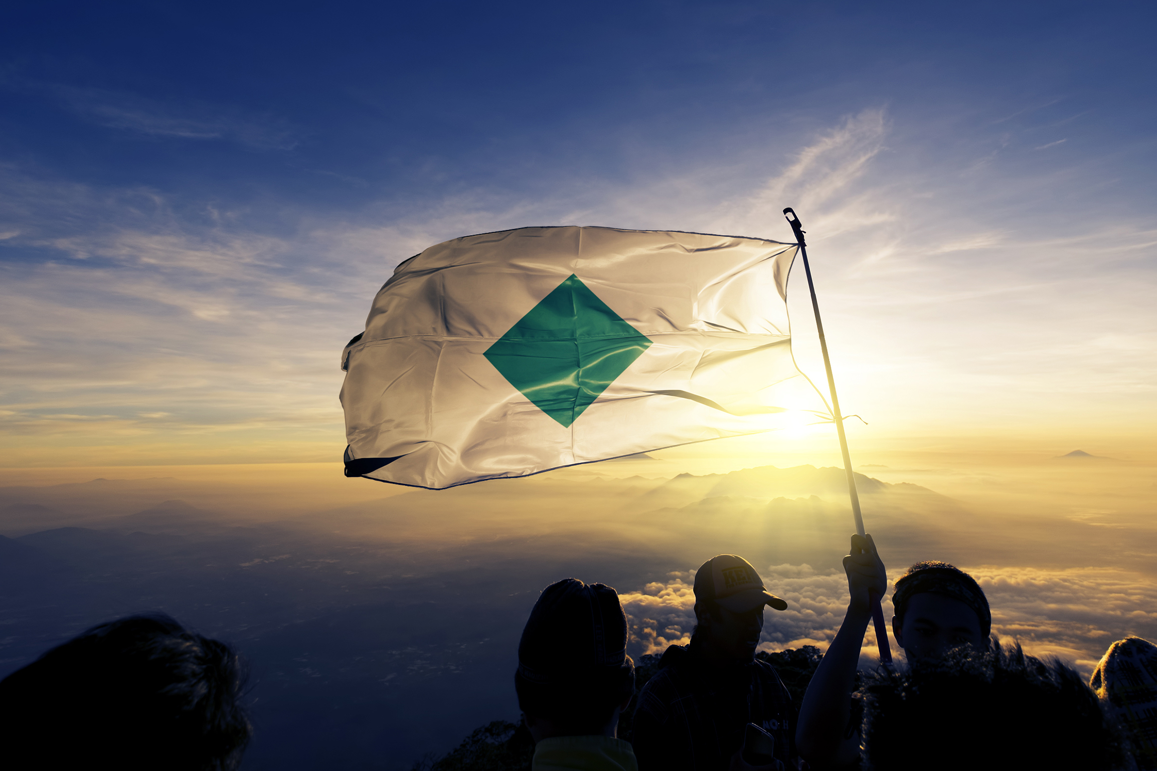 Photo of people holding the Amestrian flag on top of a mountain